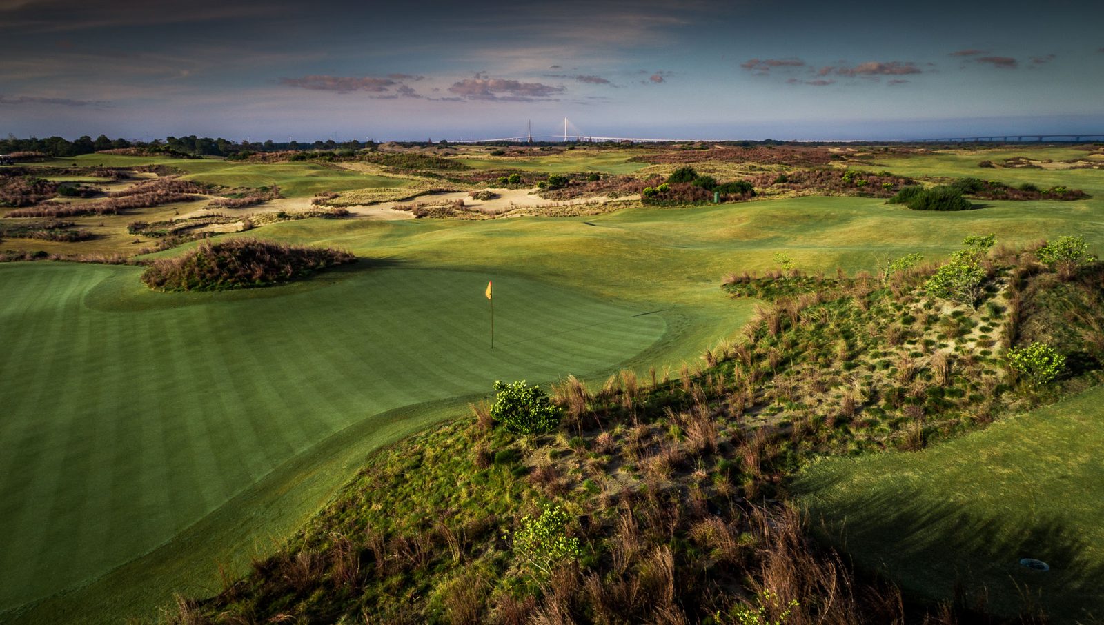 A green at Yangtze Dunes surrounded by wild sandy dunes at dusk, Chongming Island