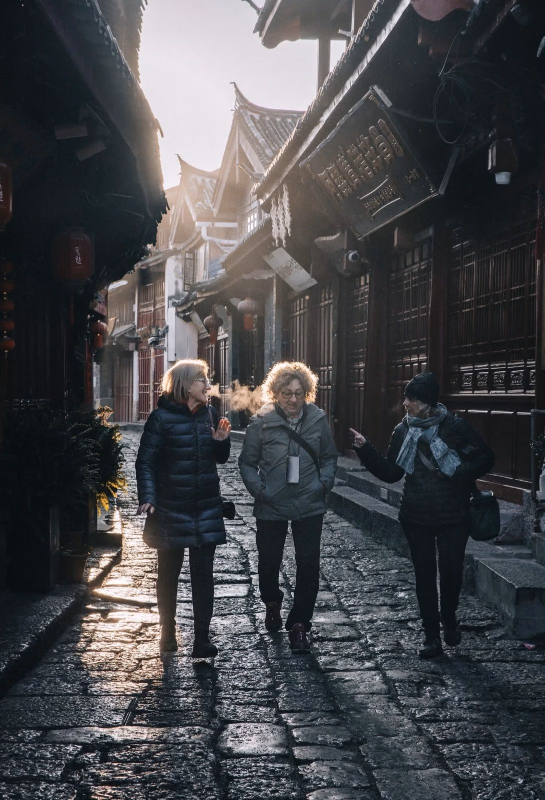 Two travelers walking Lijiang’s cobbled lanes at first light with their private guide