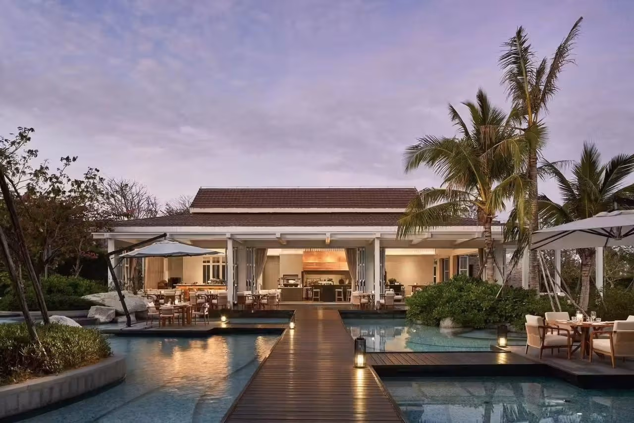 Dining pavilions set among the pools at dusk, Rosewood Sanya