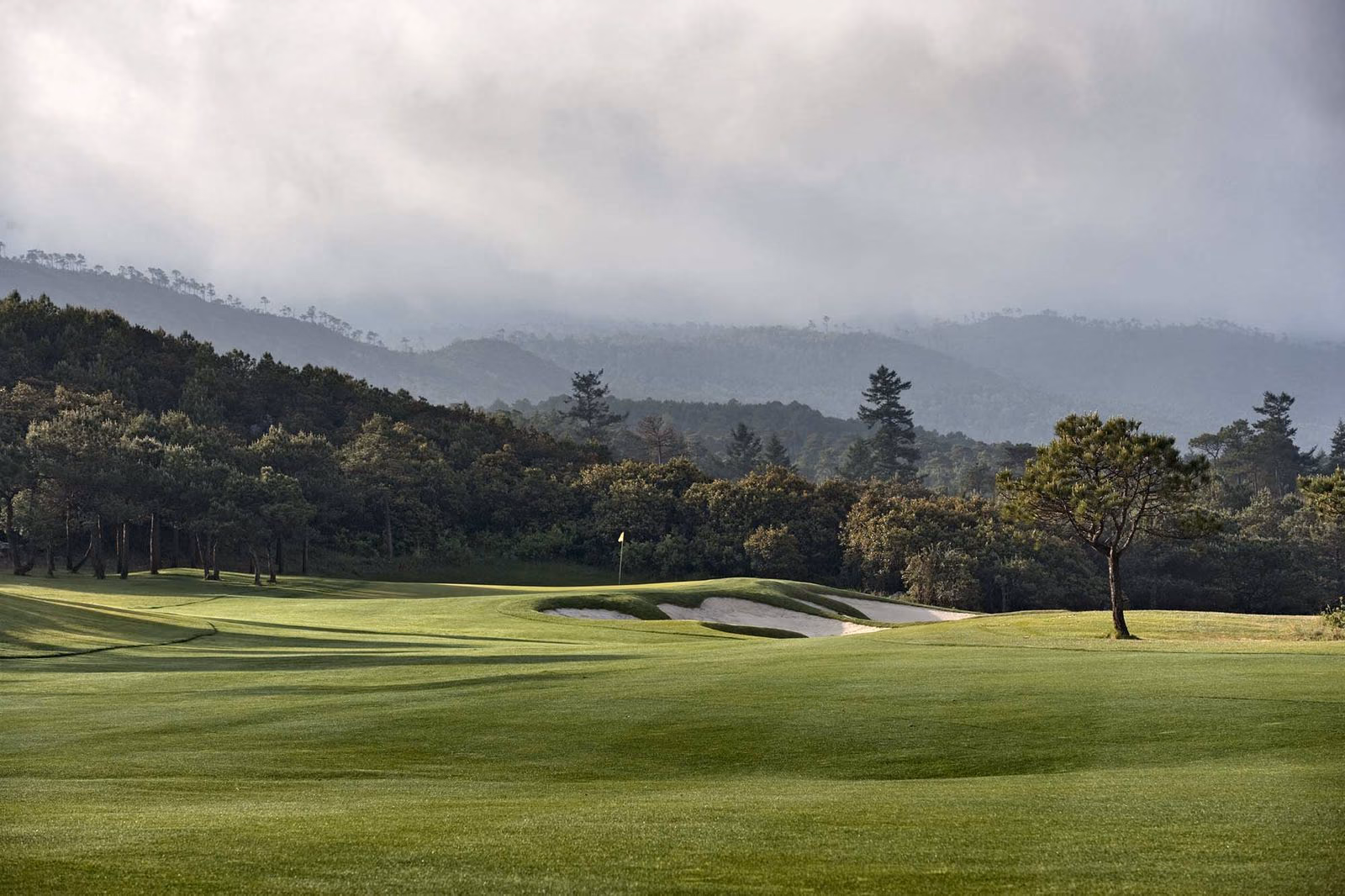 A bunkered green beneath Jade Dragon Snow Mountain