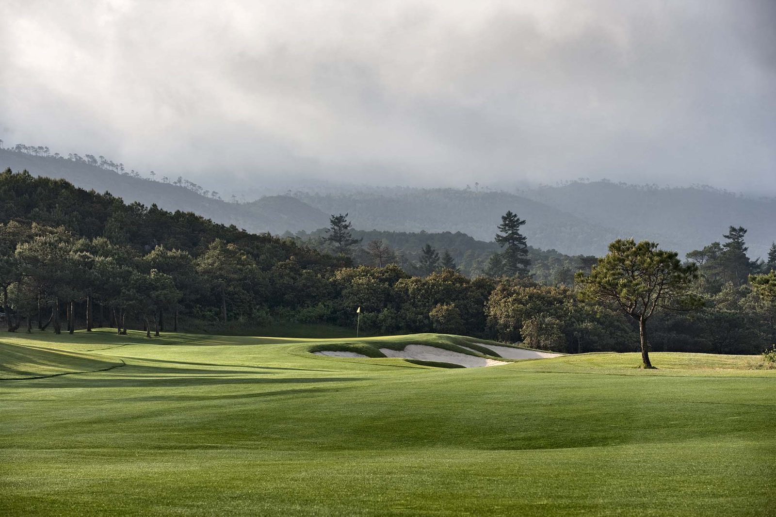 White-sand bunkers guarding a green in the thin air at Jade Dragon