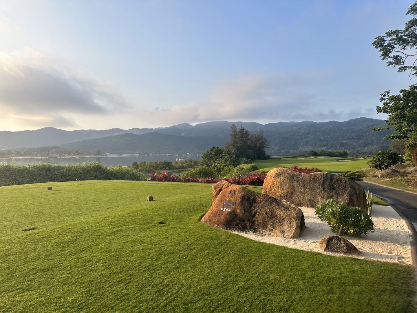 A tee box set among granite boulders beside the water at Lu Hui Tou