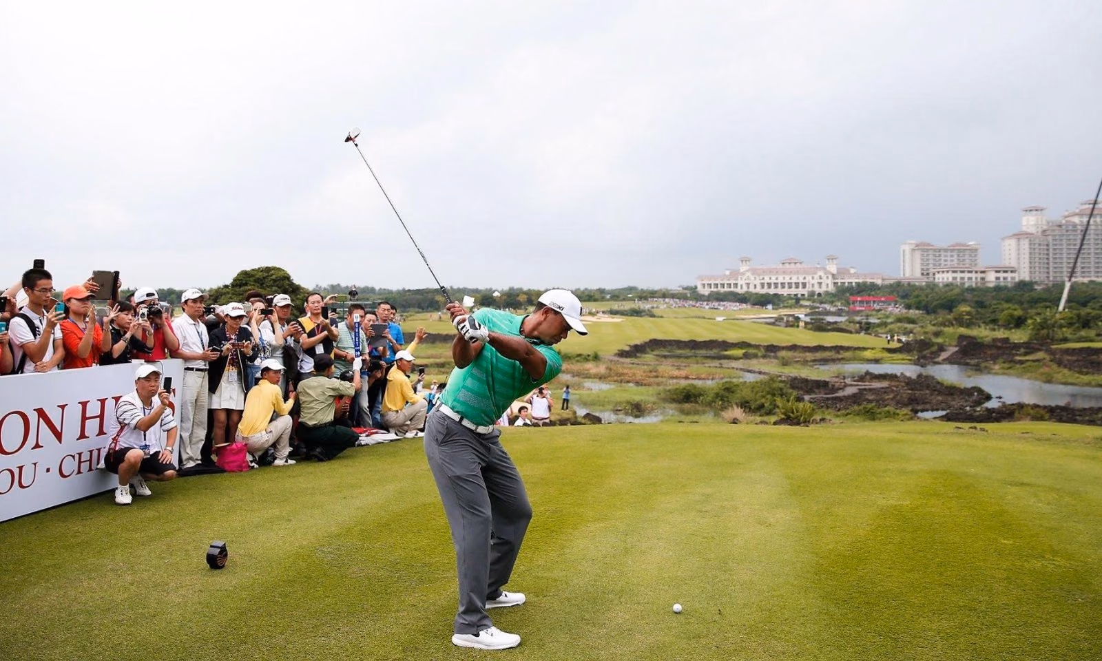Tiger Woods tees off in front of a crowd at Mission Hills Haikou, Hainan