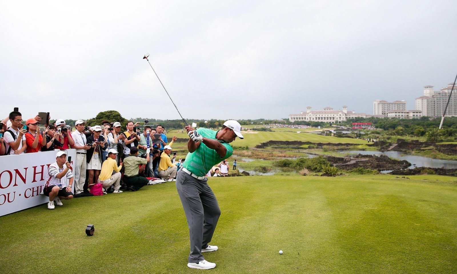 Tiger Woods tees off in front of a crowd at Mission Hills Haikou, Hainan