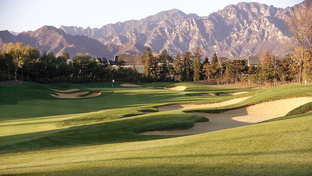 Bunkered fairways at Reignwood Pine Valley beneath the craggy Jundu Mountains