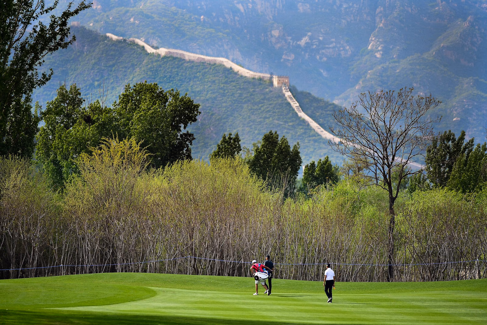 Golfers on a Reignwood Pine Valley fairway with the Great Wall snaking across the mountains behind, Beijing