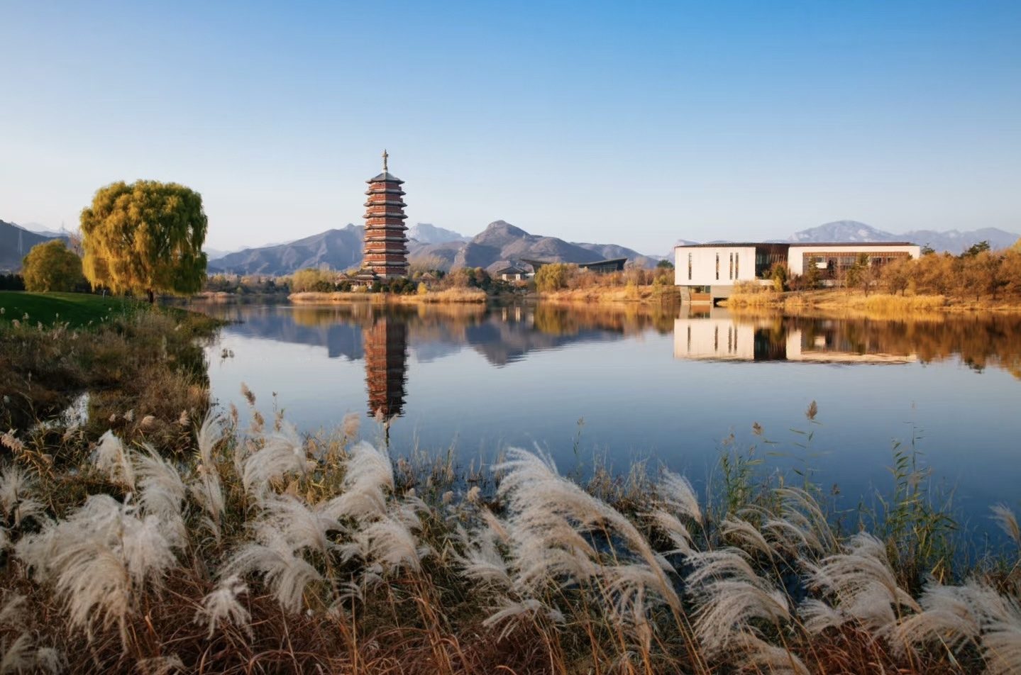 The Yanqi Lake pagoda mirrored in still water beside the course