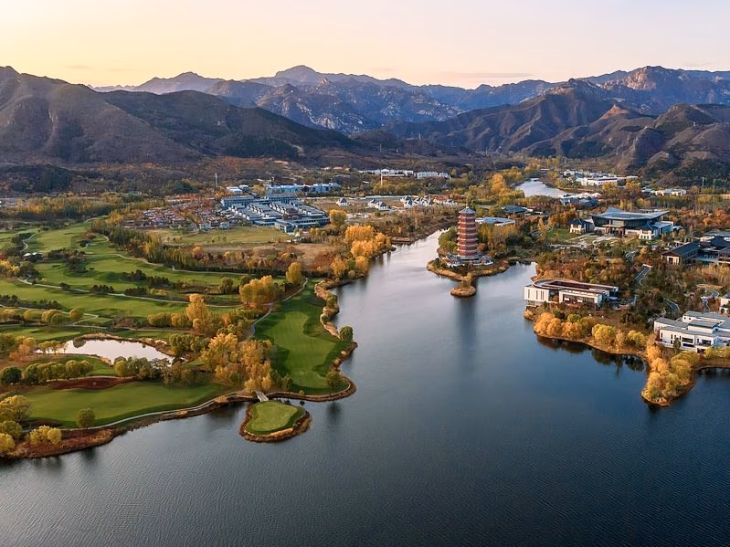 Yanqi Lake at dusk, with Topwin's lakeside greens and the pagoda below the Yanshan range